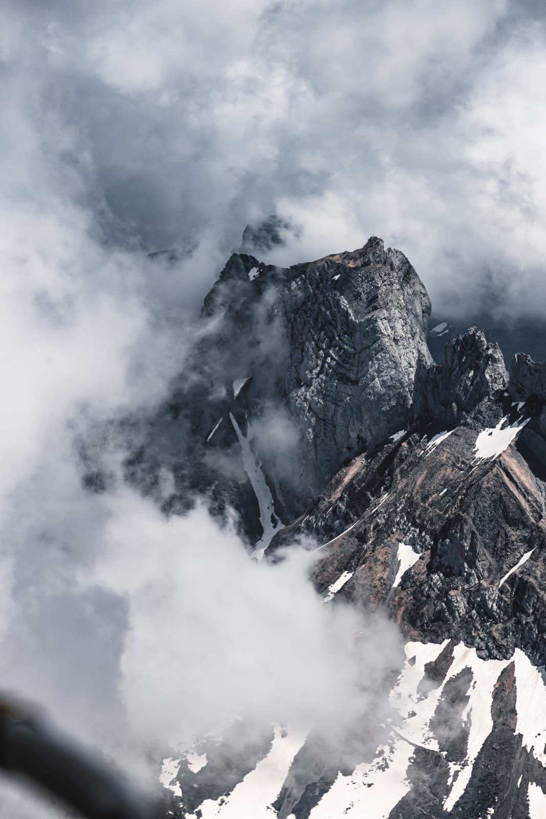 Snow-dappled mountain peak shrouded in mist